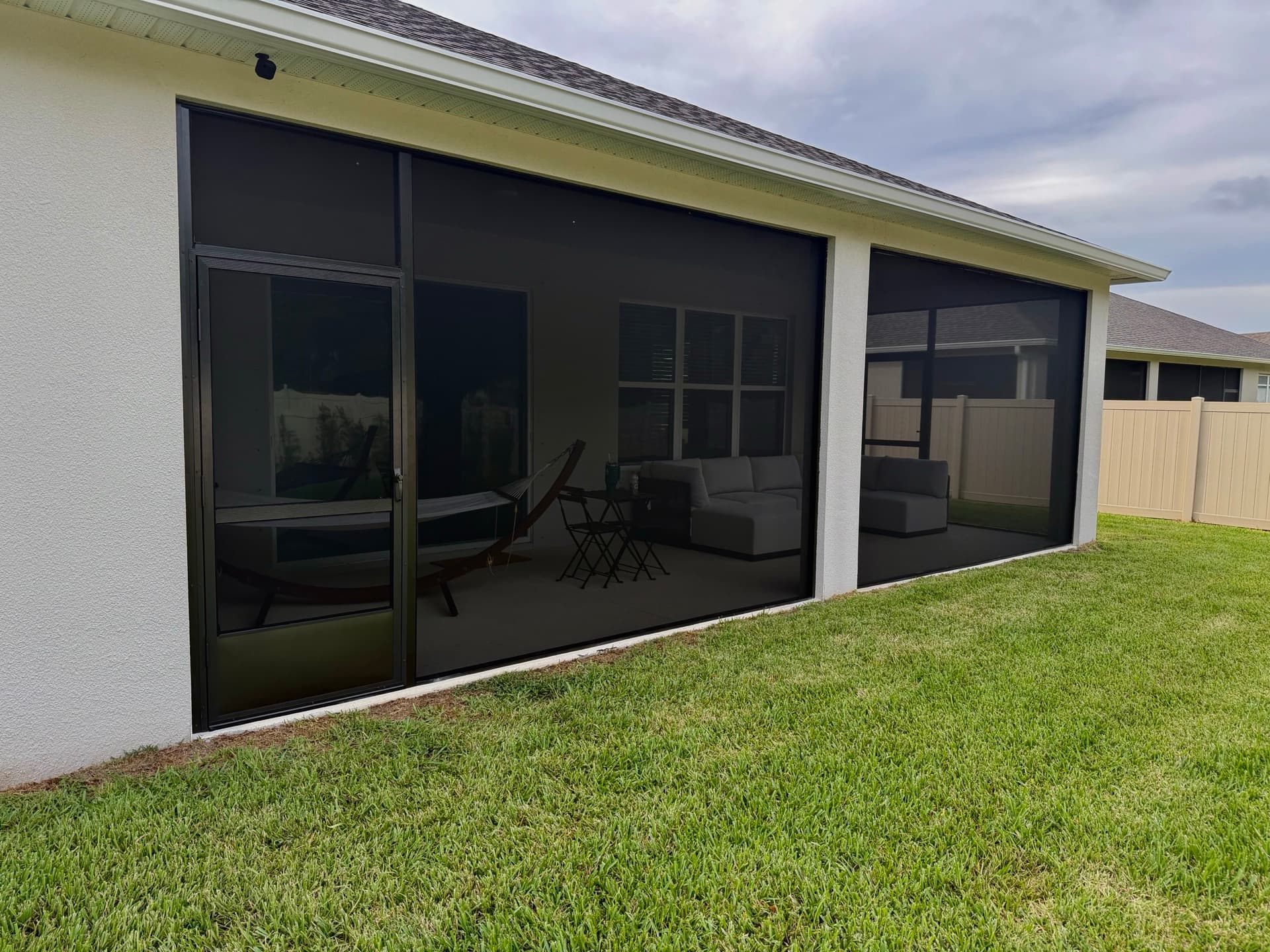 Screened porch enclosure installed on the back of a Brevard County home